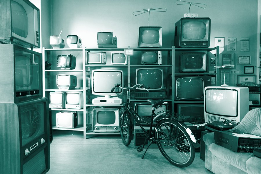 marketing trends for 2021 shows an image of a wall of old televisions in all sizes and shapes. A bike is parked in front like it might be a pawn shop.