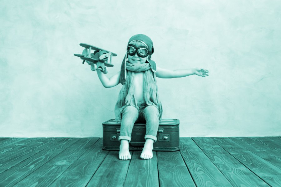 Innocent Archetype: showing a small boy wearing old aviator goggles and holding a toy plane.